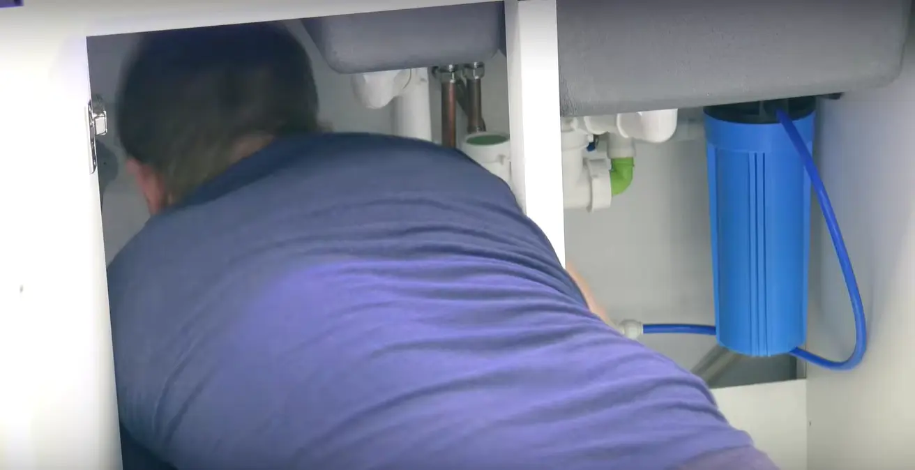 Professional drain cleaning technician clearing a kitchen sink drain in Palm Desert